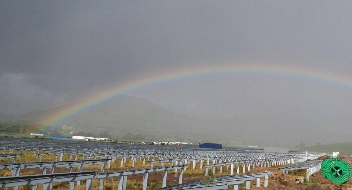 Rainbow over solar panel field