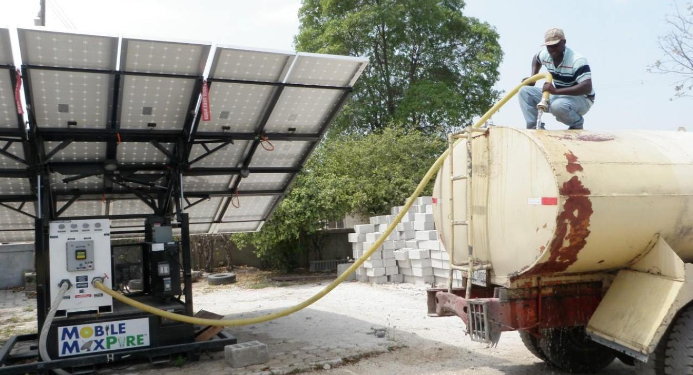 Tanker truck taking water from a solar filtration system