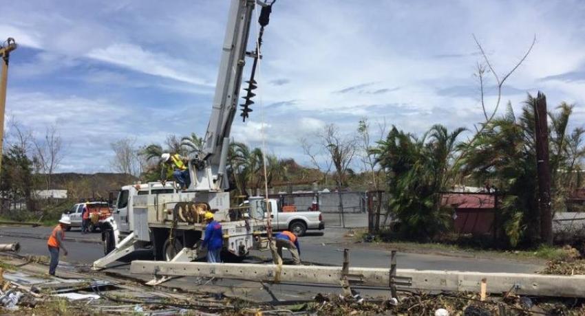 Crane lifting debris in the aftermath of Hurricane Maria